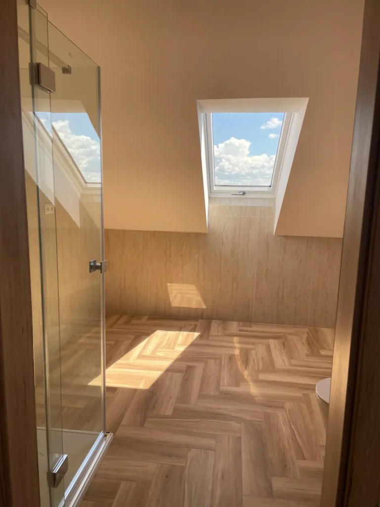 Parketta padlóburkolattal ellátott, világos fürdőszoba, zuhanykabinnal