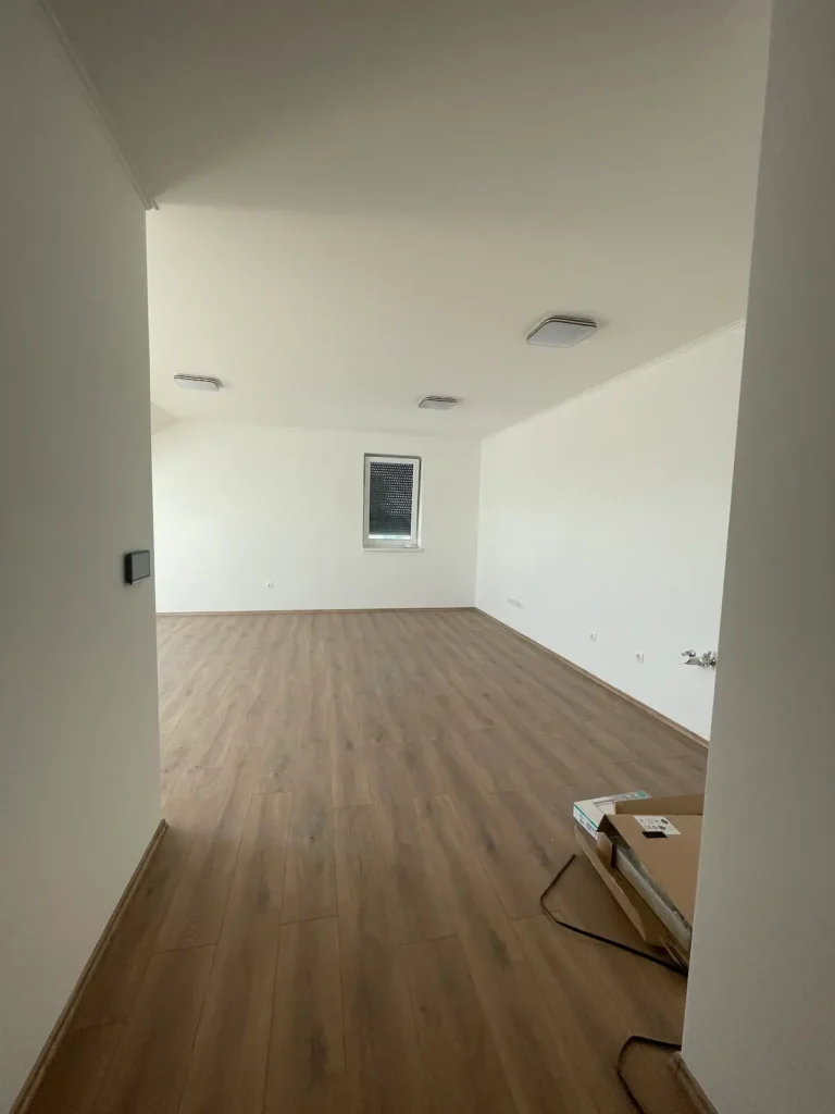 Tágas, fényes helyiség, parketta padlóburkolattal