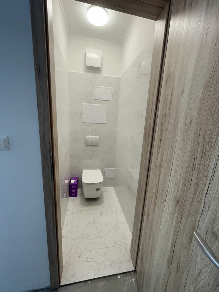 Illemhely - fehér, mintás burkolattal és fa ajtóval